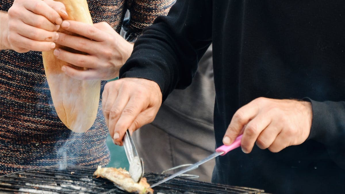 Cooking over a pellet grill with the lid open during a high-heat sear